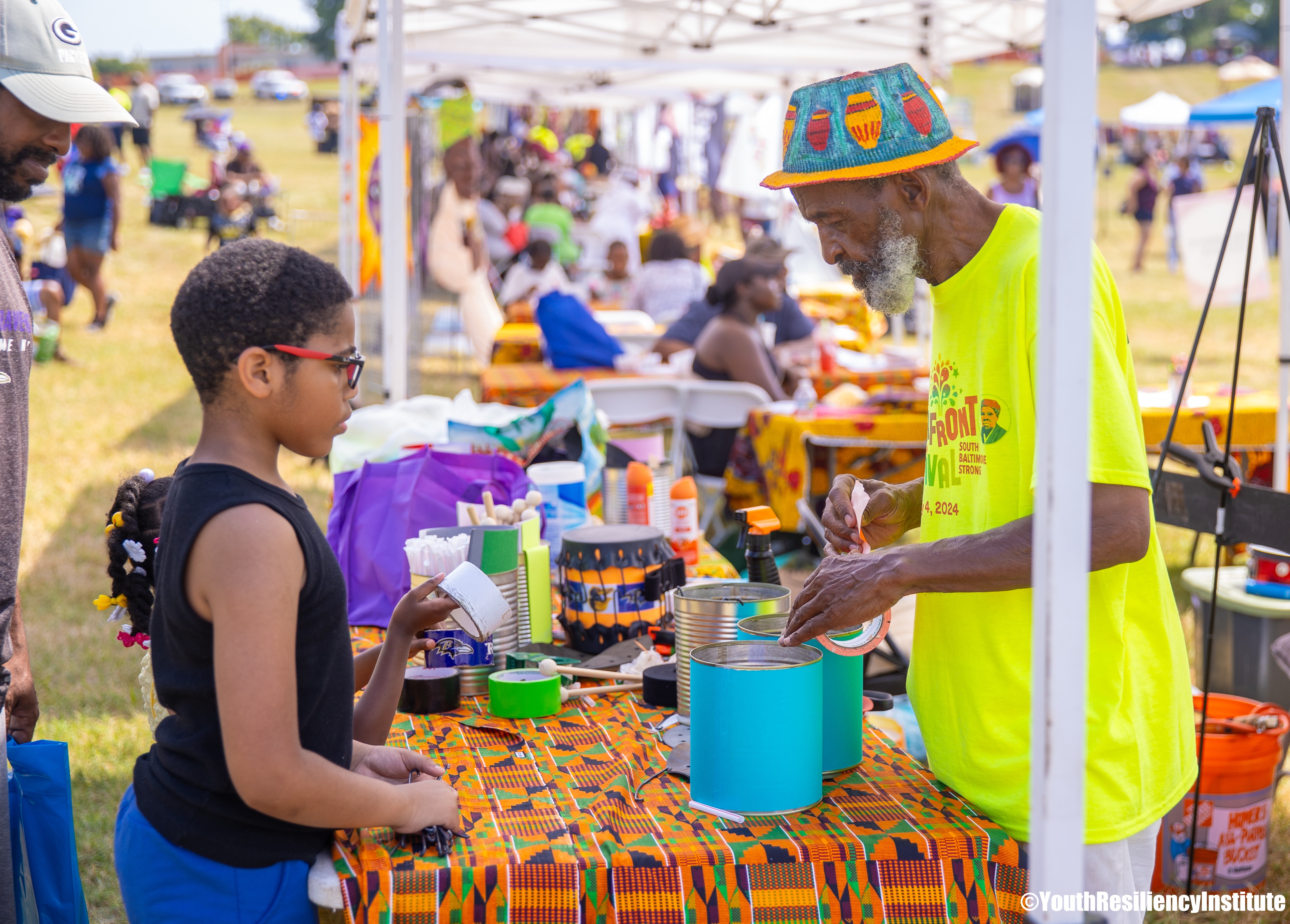 Elder and youth connecting at a craft table during the Cherry Hill Arts & Music Waterfront Festival