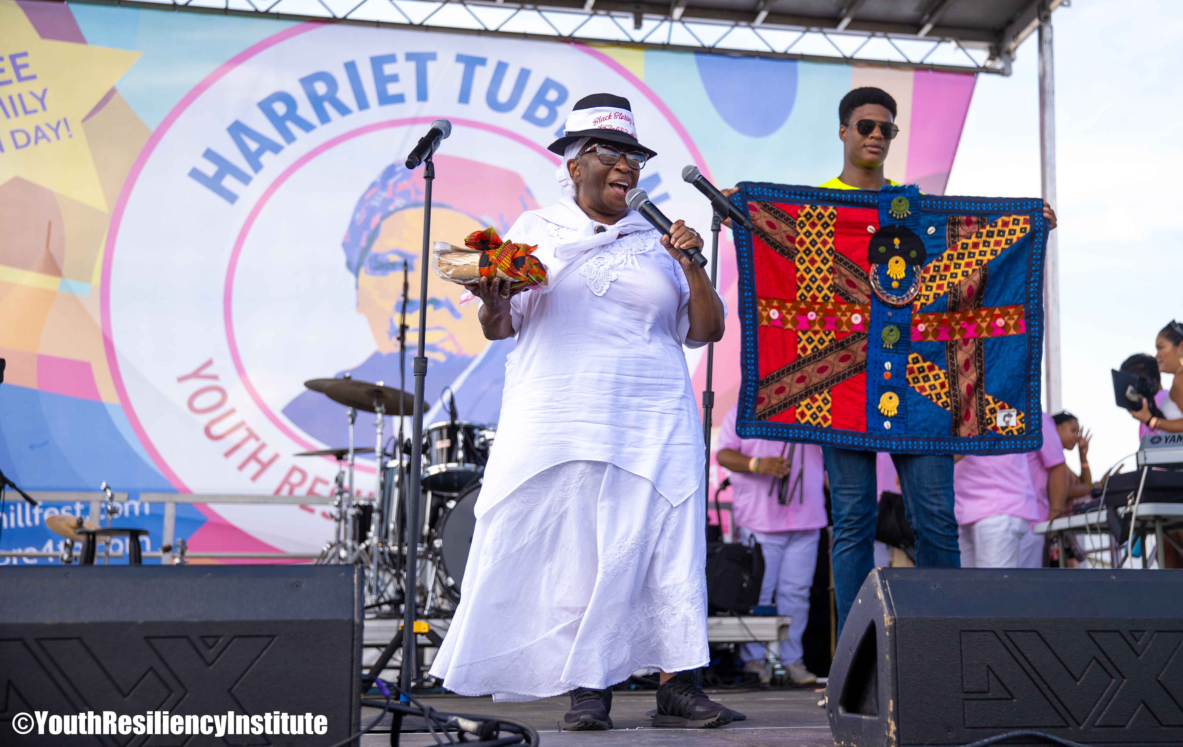 Community gathering at Cherry Hill Arts & Music Waterfront Festival with Baltimore skyline